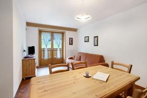 een woonkamer met een houten tafel en een bank bij Casa Michela Bilocale in Valfurva