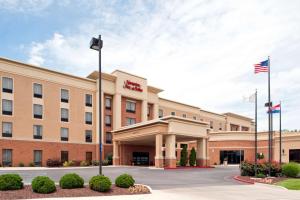 um hotel com uma bandeira americana em frente em Hampton Inn & Suites Columbia at the University of Missouri em Columbia