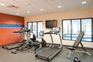 a gym with cardio machines and a flat screen tv at Hampton Inn & Suites Columbia at the University of Missouri in Columbia