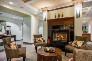 a living room with a fireplace and chairs at Hampton Inn Clifton Park in Clifton Park