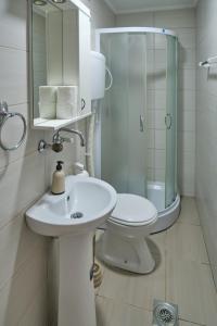 a bathroom with a sink and a toilet and a mirror at Apartmani Tvins in Soko Banja