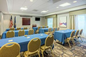 a conference room with blue tables and chairs and a podium at Hampton Inn Clifton Park in Clifton Park