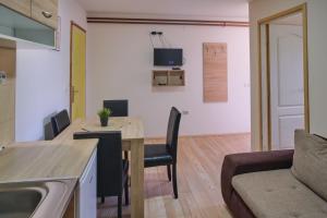 een keuken en een woonkamer met een tafel en een bank bij Apartmani Tvins in Soko Banja