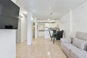a living room with a couch and a table with chairs at HE sunny terrace t in Cabo Roig