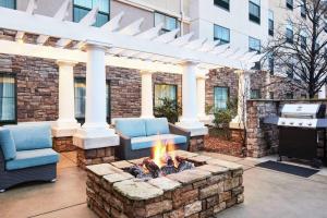 a patio with a fire pit with two chairs and a grill at Homewood Suites by Hilton Columbus in Columbus