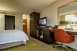 a hotel room with a bed and a desk with a television at Hampton Inn Caryville-I-75/Cove Lake-State Park in Caryville