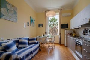a living room with a blue couch and a kitchen at Solo a Sanremo in Sanremo