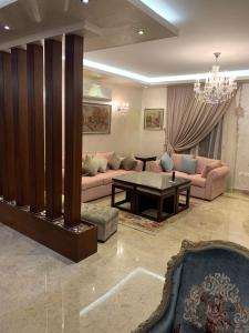 een woonkamer met een bank en een tafel bij Luxury Modern Apartment in Caïro