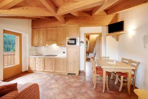 a kitchen with wooden cabinets and a table with chairs at Casa Michela Mansarda in Valfurva