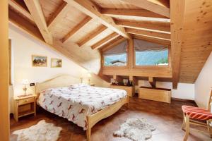 a bedroom with a bed and a large window at Casa Michela Mansarda in Valfurva