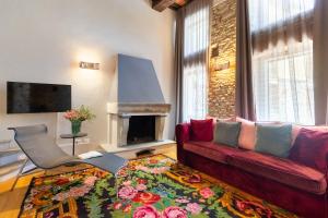 sala de estar con sofá rojo y chimenea en Relais Villa del Borgo en Canelli