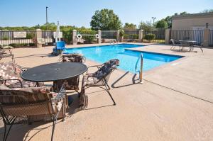 a patio with a table and chairs next to a pool at Hampton Inn Canton in Canton
