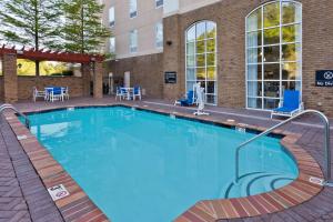 een groot zwembad in een hotel met stoelen en tafels bij Hampton Inn & Suites Phenix City- Columbus Area in Phenix City