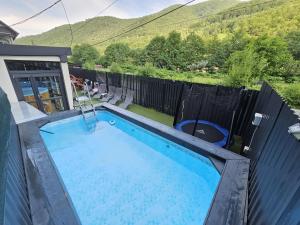 una piscina en una casa con una colina al fondo en TRANSILVANIA BLISS COTTAGE, en Someşu Rece 32 fotos más