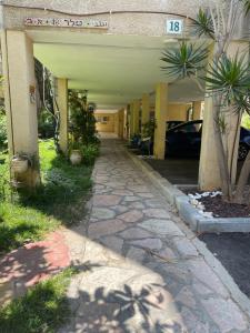 a walkway in front of a building with cars parked at Good vibes house in Rechovot