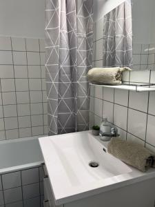 a white bathroom with a sink and a mirror at Stor 2 værelses lejlighed in Randers