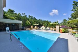 a swimming pool with chairs and umbrellas at Hampton Inn Cartersville in Cartersville