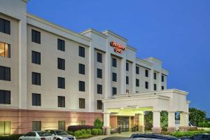 a hotel with cars parked in front of it at Hampton Inn Columbus-North in Columbus