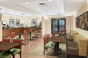 a restaurant with tables and chairs and a counter at Hampton Inn Columbus-North in Columbus