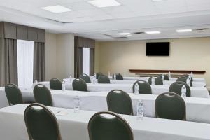 Sala de conferencias con mesas y sillas blancas y TV en Hampton Inn Columbus-North, en Columbus