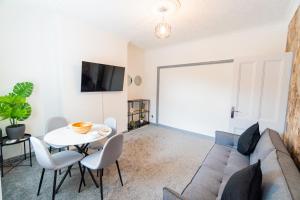 a living room with a couch and a table at Stylish 3 Bedroom House - Central Location in Nottingham