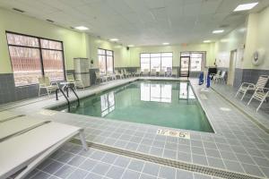 a swimming pool in a gym with chairs and tables at Hampton Inn Cincinnati Eastgate in Eastgate