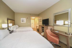 a hotel room with two beds and a desk at Hampton Inn Cincinnati Eastgate in Eastgate