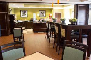 ein Restaurant mit einer Bar mit Stühlen und einer Küche in der Unterkunft Hampton Inn Cincinnati Northwest Fairfield in Fairfield