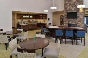 a restaurant with tables and chairs and a kitchen at Homewood Suites by Hilton Cincinnati/Mason in Mason