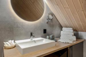 La salle de bains est pourvue d'un lavabo blanc et d'un miroir. dans l'établissement Wangen Apartments AS, à Aurland