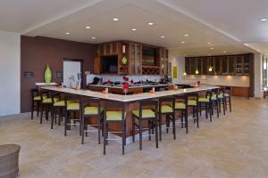 a large kitchen with a large bar with stools at Hilton Garden Inn West Chester in West Chester