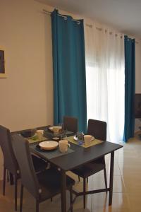 a dining room table with chairs and a blue curtain at Charming House in Kástron +26 photos
