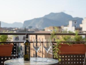 - une bouteille de vin assise sur une table avec deux verres dans l'établissement Central Station Home - Fanale Rentals, à Palerme