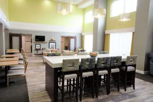 Hampton Inn & Suites Palm Coast في فلاغلار بيتش: غرفة معيشة مع طاولة وكراسي كبيرة