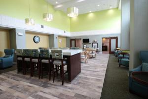 a lobby with a bar and chairs and a waiting room at Hampton Inn & Suites Palm Coast in Flagler Beach