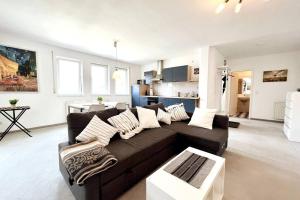 sala de estar con sofá marrón y cocina en Cozy-Livings / Parkplatz, TOP-Lage, Balkon, Küche, en Neu-Anspach