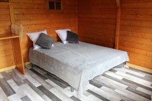 a bed with two pillows on it in a room at LES GRANGES D'ANTAN - le REFUGE FORESTIER - INSOLITE SANS EAU - ELECTRICITE AVEC BATTERIE NOMADE in Chalonnes-sous-le-Lude