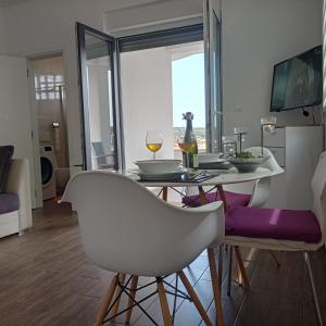 a dining room with a table with two white chairs at Istrian Azure in Pula