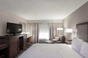 a hotel room with a bed and a flat screen tv at Hampton Inn & Suites Dallas DFW Airport North Grapevine in Grapevine