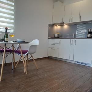 a kitchen with white cabinets and a table and chairs at Istrian Azure in Pula