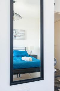 a mirror reflecting a bed in a bedroom at T2 Entre plage et centre ville-Terrasse/Parking in Marseille