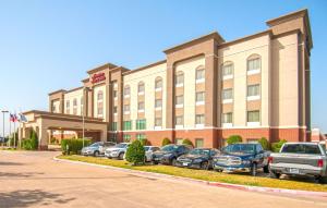 a hotel with cars parked in front of it at Hampton Inn and Suites Waxahachie in Waxahachie