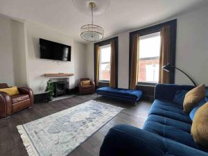 a living room with a blue couch and a tv at Marina Lodge in Gosport