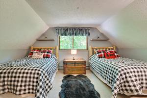 two beds in a attic room with a dog laying between them at Gaylord Cabin with Game Room and Lake Access! in Gaylord