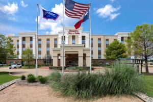 dos banderas volando delante de un edificio en Hampton Inn & Suites Dallas-DeSoto, en DeSoto