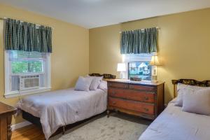 a bedroom with two beds and a dresser and two windows at Dog-Friendly Fitchburg Vacation Rental, Hike and Ski in Fitchburg