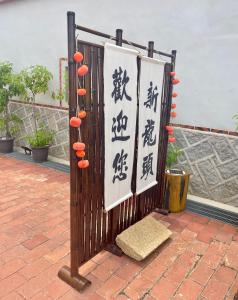 una puerta con escritura china en un patio en 新龍頭古厝行館 Shin Long Tou B&B, en Jinning