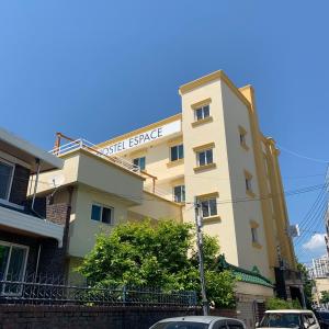 a building with a sign on top of it at Hostel Espace in Chuncheon