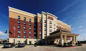 ein Hotel mit einer amerikanischen Flagge davor in der Unterkunft Hampton Inn and Suites Dallas/Lewisville-Vista Ridge Mall in Lewisville