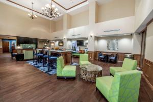 un vestíbulo con sillas verdes y un bar en Hampton Inn Dallas-Rockwall, en Rockwall